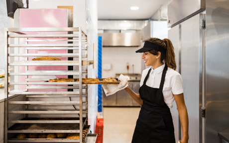 female worker in the kitchen sorting baked goods